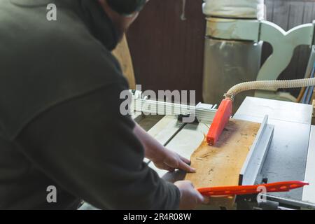 Tischler verschiebbare Holzbohle unter der Tischkreissäge zum Schneiden von Holz in Holzwerkstätten. Hochwertiges Foto Stockfoto