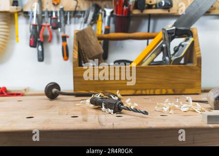 Nahaufnahme des Holztisches des Zimmermanns mit Holzbearbeitungswerkzeugen in der Werkstatt. Hochwertiges Foto Stockfoto