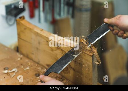 Arbeiten auf Holz mit einem Wagenheber, den Werkzeugen des Zimmermanns. Hochwertiges Foto Stockfoto
