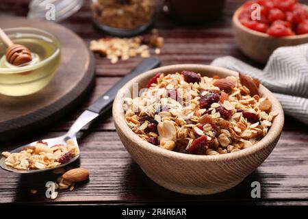 Leckeres Müsli mit Nüssen und trockenen Früchten auf einem Holztisch Stockfoto