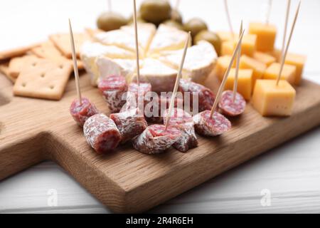 Zahnstocher-Vorspeisen. Würstchen auf Holzbrett, Nahaufnahme Stockfoto