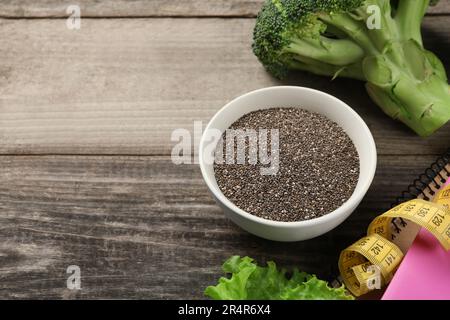 Chiasamen, Maßband und Brokkoli auf Holztisch, Platz für Text. Gewichtsverlust-Konzept Stockfoto