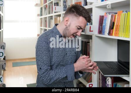 Mann mit Hand und Finger in Pain​ mit roter Markierung Stockfoto