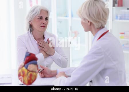 Frau beklagt sich über Herzschmerzen beim Arzt im Krankenhaus Stockfoto