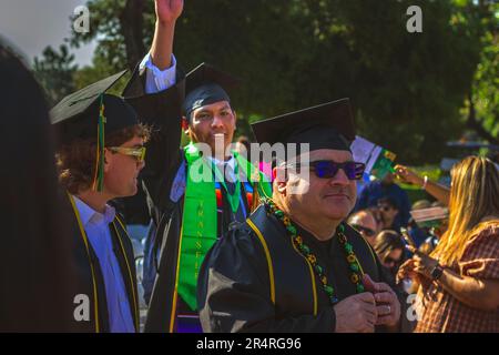 Ein aufbauendes Bild, in dem der 2023-Absolvent Gio Skelton winkt, während er mit seiner Klasse spaziert, um seinen Abschluss am Crafton Hills College Commencement zu erhalten Stockfoto