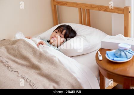 Japanisches Kind krank im Bett Stockfoto