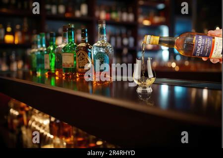 Die Auswahl an luxuriösen Whiskys steht an der Bar vor dem Hintergrund von Bar und Flaschen, die nicht im Fokus stehen. Stockfoto
