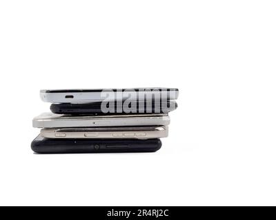 Beschädigte Mobiltelefone. Ein Haufen kaputter Smartphones. Benutzte Telefone mit hellem Hintergrund. Stockfoto
