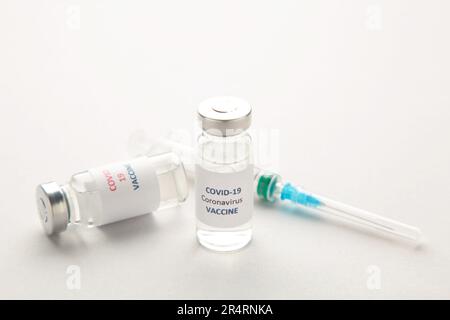 Coronavirus COVID-19-Impfstofffläschchen und Spritze auf grauem Hintergrund mit Kopierraum. Draufsicht Stockfoto