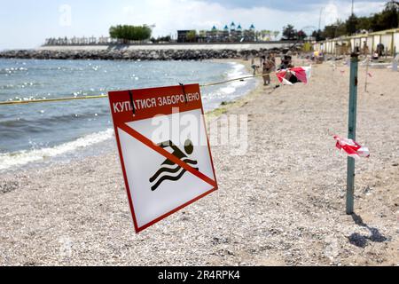 Leuchtend rotes Schild „No Swimming“ am Sandstrand der Stadt in Odessa während Russlands Angriff auf die Ukraine. Schwimmen ist verboten! Sie nähern sich dem Wasser Stockfoto