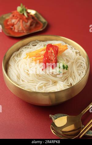 Janchi Guksu, traditionelle koreanische weiße Somen-Nudelsuppe mit Sardellenbouillon und verschiedenen Belägen, serviert mit Kimchi. Party-Bankettmenü in koreanischer Küche Stockfoto
