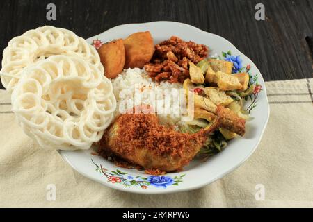 Nasi Warteg mit gebratenem Hühnchen Lengkuas, Reis mit verschiedenen Beilagen und Crackern Stockfoto