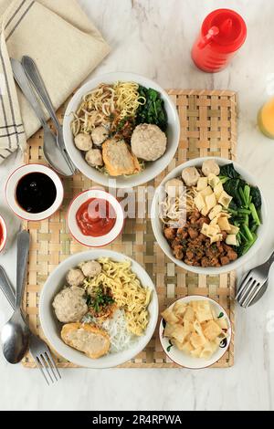 Top View verschiedene Bakso und Mie Ayam auf weißem Marmortisch Stockfoto