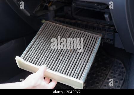 Austausch des AR-Fahrerhausfilters des Fahrzeugs. Austausch des verschmutzten Luftfilters. Stockfoto