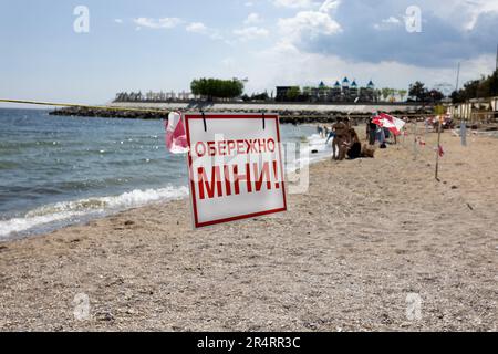 ODESSA, UKRAINE - 15. MAI 2023: Minengefahrenschild am Sandstrand des städtischen Meeres in Odessa während des russischen Angriffs auf die Ukraine. Schwimmen ist verboten! Ca Stockfoto