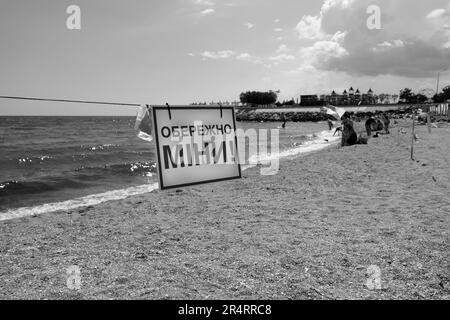 ODESSA, UKRAINE - 15. MAI 2023: Minengefahrenschild am Sandstrand des städtischen Meeres in Odessa während des russischen Angriffs auf die Ukraine. Schwimmen ist verboten! Ca Stockfoto