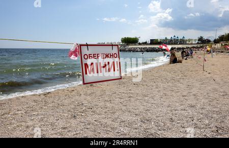 ODESSA, UKRAINE - 15. MAI 2023: Minengefahrenschild am Sandstrand des städtischen Meeres in Odessa während des russischen Angriffs auf die Ukraine. Schwimmen ist verboten! Ca Stockfoto