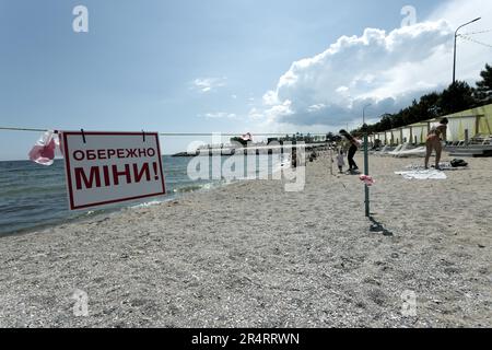 ODESSA, UKRAINE - 15. MAI 2023: Minengefahrenschild am Sandstrand des städtischen Meeres in Odessa während des russischen Angriffs auf die Ukraine. Schwimmen ist verboten! Ca Stockfoto