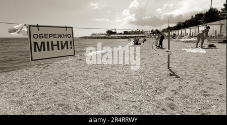 ODESSA, UKRAINE - 15. MAI 2023: Minengefahrenschild am Sandstrand des städtischen Meeres in Odessa während des russischen Angriffs auf die Ukraine. Schwimmen ist verboten! Ca Stockfoto