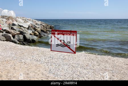 Leuchtend rotes Schild „No Swimming“ am Sandstrand der Stadt in Odessa während Russlands Angriff auf die Ukraine. Schwimmen ist verboten! Sie nähern sich dem Wasser Stockfoto