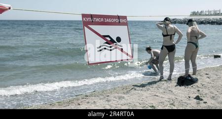 ODESSA, UKRAINE - 15. MAI 2023: "Schwimmen ist verboten"-Schild am Sandstrand der Stadt in Odessa während des russischen Angriffs auf die Ukraine. Schwimmen ist es Stockfoto