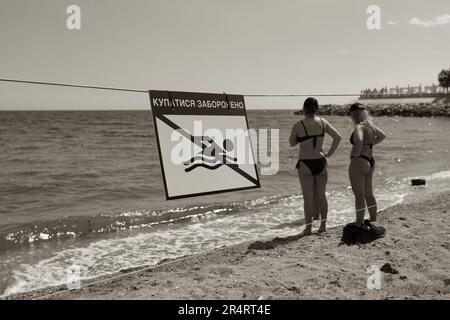 ODESSA, UKRAINE - 15. MAI 2023: "Schwimmen ist verboten"-Schild am Sandstrand der Stadt in Odessa während des russischen Angriffs auf die Ukraine. Schwimmen ist es Stockfoto