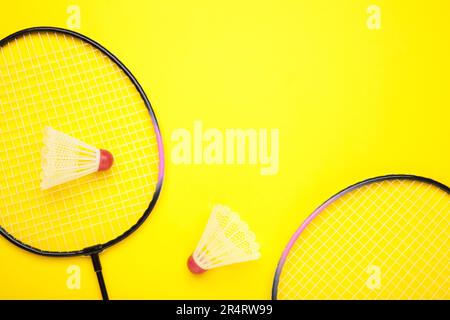 Shuttles und Badminton-Schläger auf gelbem Hintergrund. Draufsicht. Stockfoto