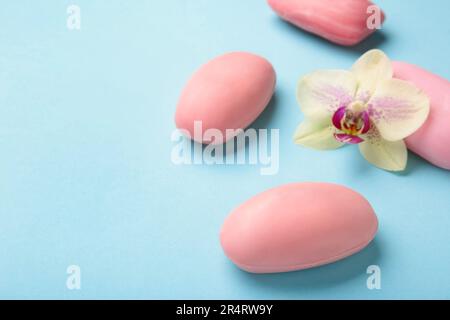 Verschiedene rosa Seifen mit Blumen. Viel feste Seife für Hygiene und Sauberkeit auf blauem Hintergrund. Draufsicht. Stockfoto