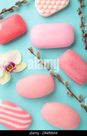 Verschiedene rosa Seifen mit Blumen. Viel feste Seife für Hygiene und Sauberkeit auf blauem Hintergrund. Draufsicht. Stockfoto