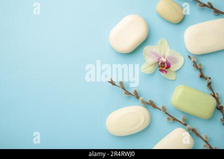 Verschiedene weiße Seifen mit Blumen. Viel feste Seife für Hygiene und Sauberkeit auf blauem Hintergrund. Draufsicht. Stockfoto