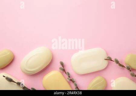 Verschiedene weiße Seifen mit Blumen. Viel feste Seife für Hygiene und Sauberkeit auf pinkfarbenem Hintergrund. Draufsicht. Stockfoto