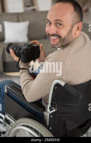 Porträt eines lächelnden Mannes mit einer spiegellosen Kamera Stockfoto
