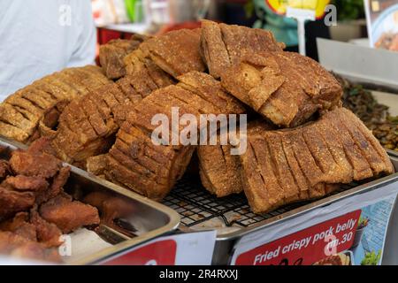 Nahaufnahme des gebratenen knusprigen Schweinebauchs, der auf dem Basar verkauft wird. Stockfoto