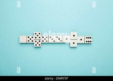 Dominosteine auf blauem Hintergrund spielen. Domino-Effekt. Draufsicht Stockfoto