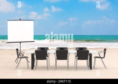 Projektionsleinwand, Tisch und Stühle als Bürokonzept auf einem Meer- oder Sea Summer Sand Beach Hintergrund. 3D-Rendering Stockfoto