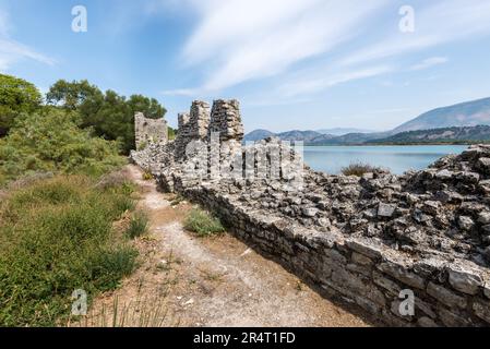 Ruinen einer alten Festungsmauer am Ufer und Salzlagune am Butrint-See, wunderschöne Aussicht vom Butrint-Nationalpark, der zum UNESCO-Weltkulturerbe gehört Stockfoto