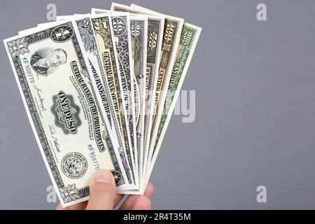 Altes philippinisches Geld - Peso in der Hand auf grauem Hintergrund Stockfoto