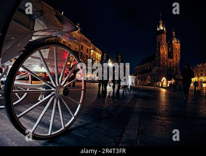 Nachtfoto des zentralen Platzes Rynok Glavny mit St. Marienkirche in Krakau, Polen Stockfoto