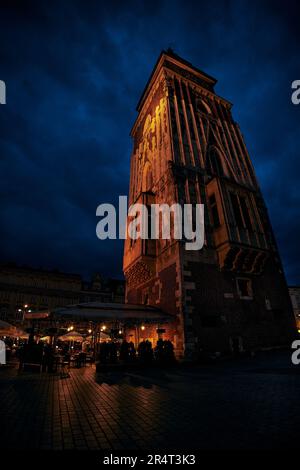 Vertikales Nachtfoto des zentralen Platzes Rynok Glavny mit dem Rathausturm in Krakau Polen Stockfoto