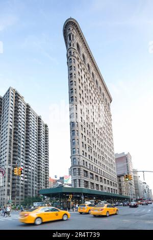 USA, New York, das Flatiron Building entlang des Broadway mit den gelben Taxis. Stockfoto