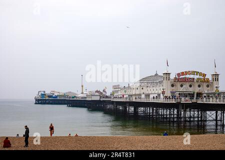 Brighton, Großbritannien - Mai 19 2019: Der Kieselstrand in Brighton an einem bewölkten Tag, an dem der Brighton Palace Pier und die Menschen am Strand zu sehen sind. Stockfoto