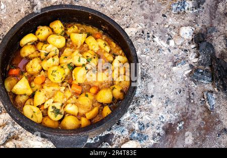 Kartoffeln und Fleisch in einem Kessel auf Holzkohle gekocht, serbische Küche. Stockfoto