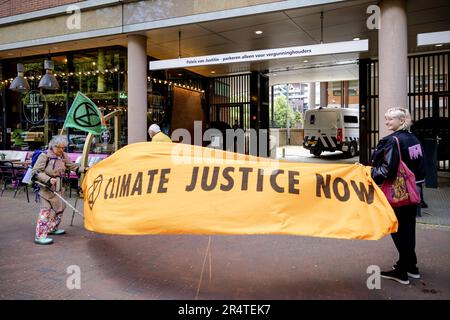 DEN HAAG - Demonstranten, die Sympathisanten des Aussterbens der Rebellion am Gerichtshof in Den Haag während der Anklage eines Klimaaktivisten demonstrieren, der während der Blockade der A12 Jahre verhaftet wurde, werden dem Untersuchungsrichter vorgelegt. Der Mann widersetzte sich der Verhaftung und biss einen Polizisten. ANP ROBIN VAN LONKHUIJSEN niederlande raus - belgien raus Stockfoto