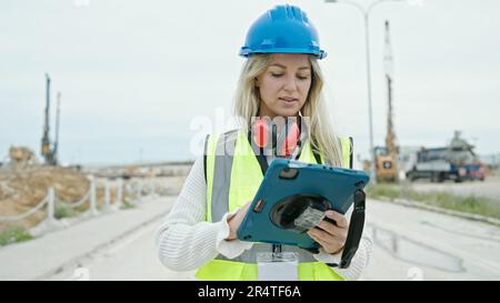 Junge blonde Architektin mit Touchpad auf der Straße Stockfoto