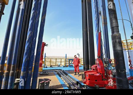 (230530) -- URUMQI, 30. Mai 2023 (Xinhua) -- ein Ingenieur inspiziert den Betrieb einer Bohrmaschine beim Bohrprojekt einer über 10.000 Meter tiefen Bohrung für die wissenschaftliche Erforschung in der Autonomen Region Xinjiang Uygur im Nordwesten Chinas, 30. Mai 2023. Die Bohrungen in Chinas erstem Bohrloch mit einer Tiefe von mehr als 10.000 Metern für die wissenschaftliche Erforschung begannen am Dienstag im Tarim-Becken, der Autonomen Region Xinjiang Uygur im Nordwesten Chinas. Die Operation begann am Dienstag um 11:46 Uhr. Es ist ein Meilenstein in der Erforschung der tiefen Erde Chinas und bietet eine beispiellose Gelegenheit, sie zu studieren Stockfoto