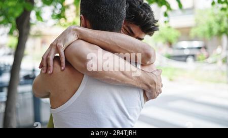 Zwei Männer, die sich im Park umarmen Stockfoto