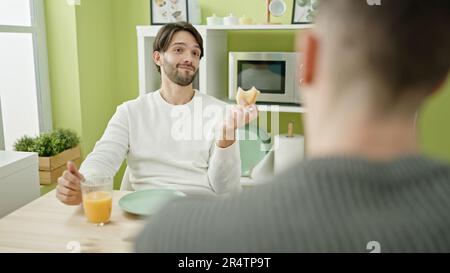 Zwei Männer, die selbstbewusst lächeln, frühstücken im Speisesaal Stockfoto