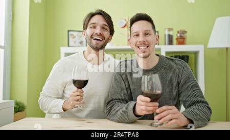 Zwei Männer, die selbstbewusst ein Glas Wein im Speisesaal trinken Stockfoto