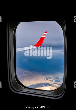 Kaukasusgebirge - aus der Vogelperspektive von einem Fensterplatz im Flugzeug. Flugzeugflügel durch das Fenster in einer Flugzeugkabine gesehen Stockfoto
