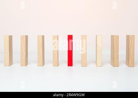 Ein roter Holzblock zwischen dem Holzblock auf weißem Hintergrund. Ein anderes Konzept sein. Stockfoto